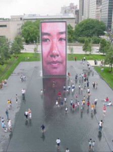 Looking toward the south tower of Crown Fountain as a crowd gathers in and around the reflecting pool on Millennium Park's opening day.