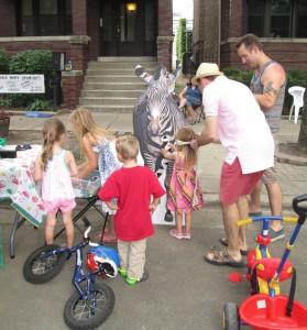 Children's Librarian Caleb Nolan helps neighborhood children play Pin the Tail on the Zebra