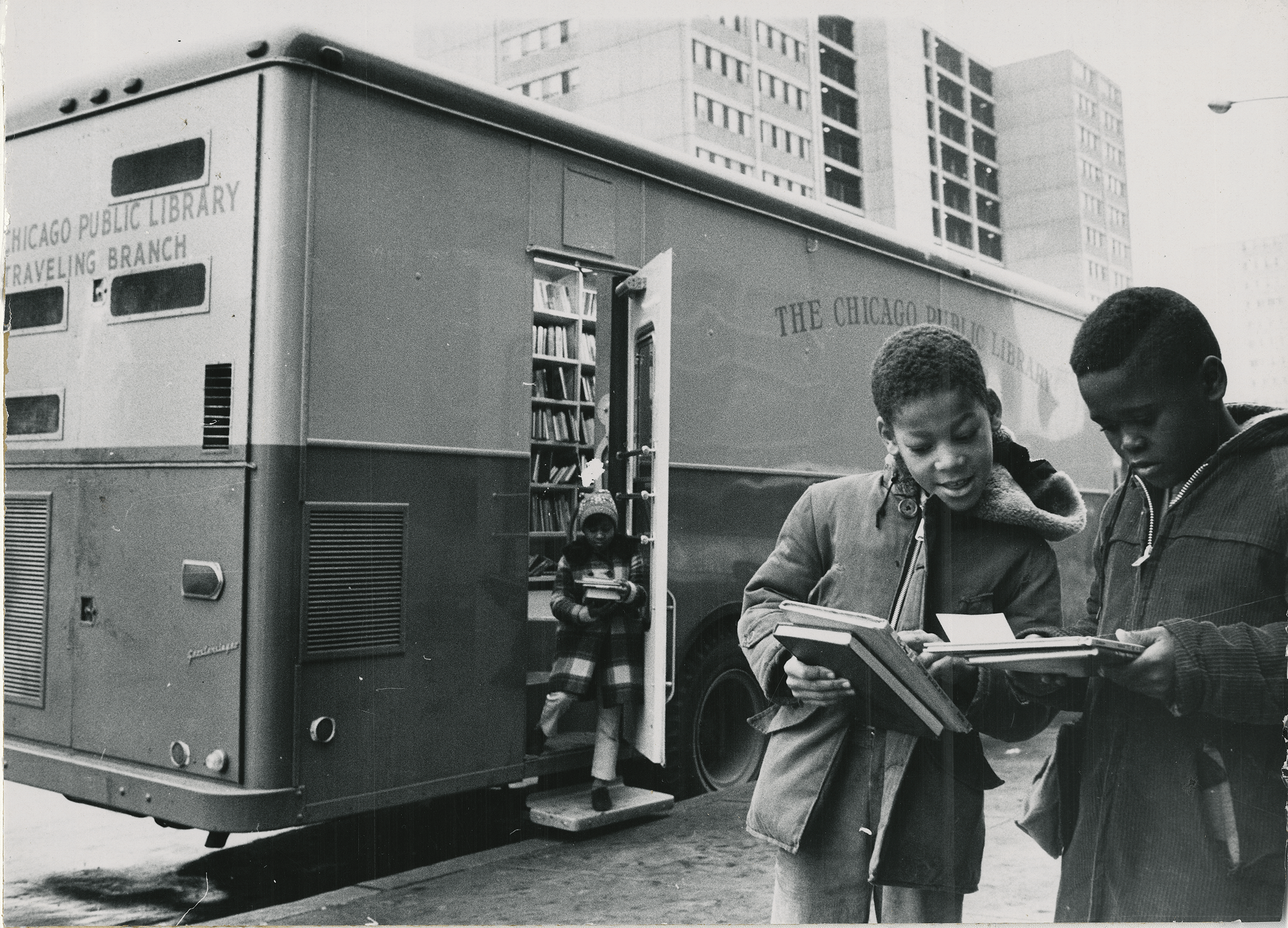 Kids looking through books outside the CPL Traveling Branch